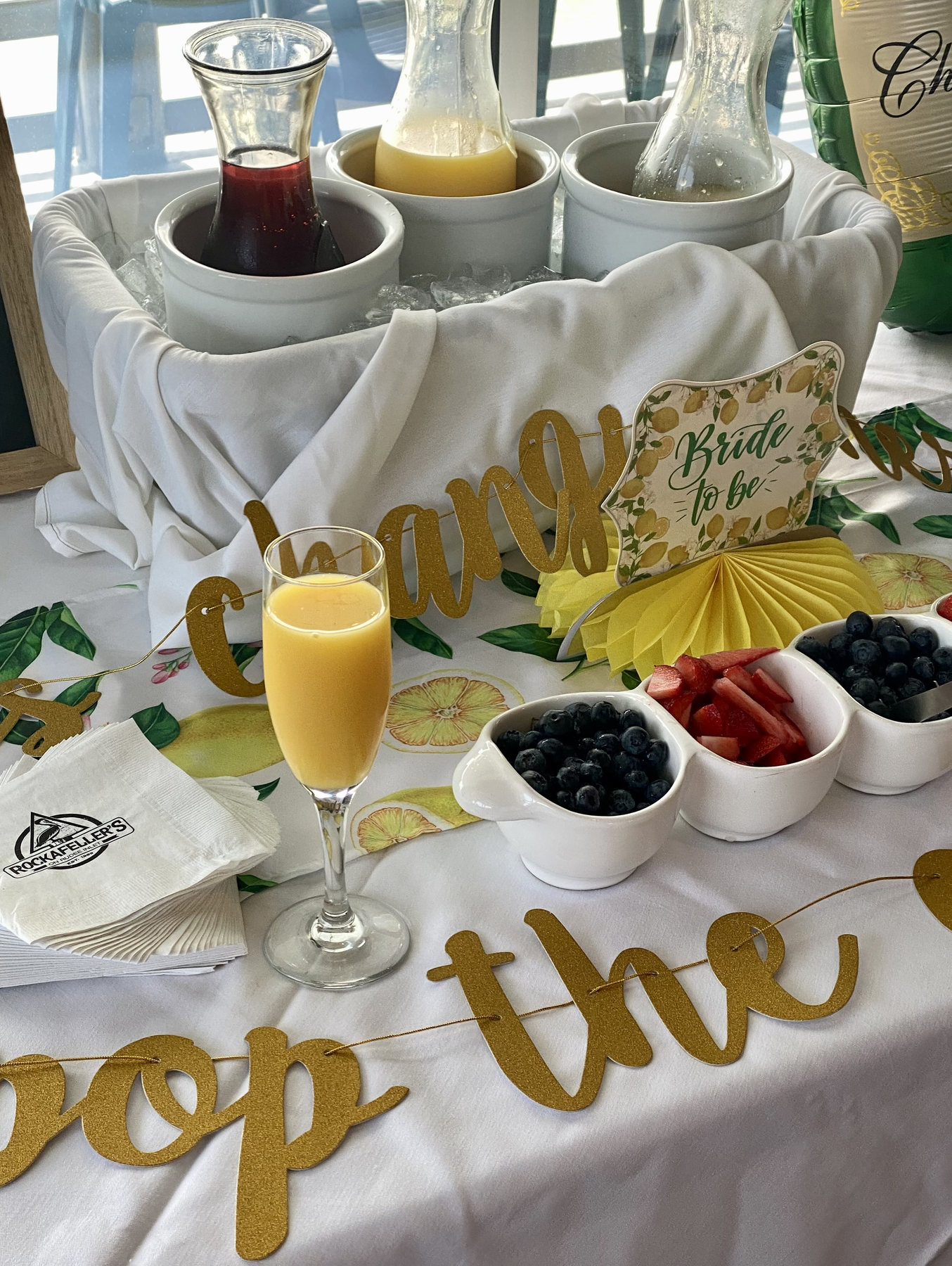 Styled brunch table with fruit, drinks, and yellow decorations