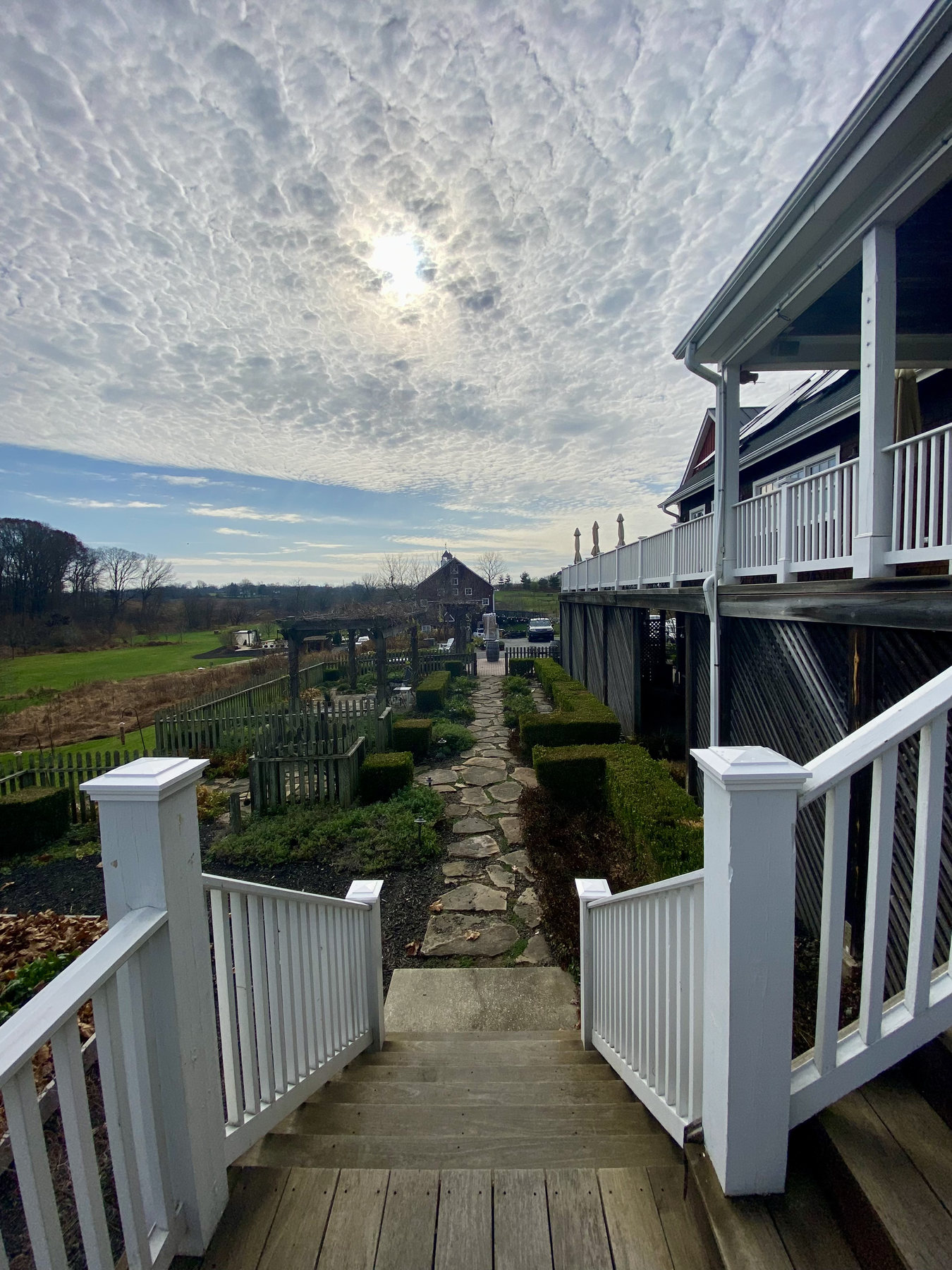 Steps and white railings leading toward a wide country view